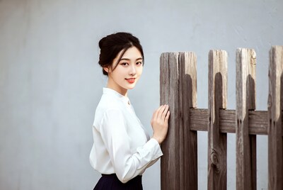 Young Asian woman by wooden fence