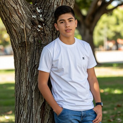 Teen boy leaning on tree