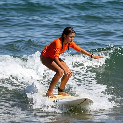Young girl surfing wave