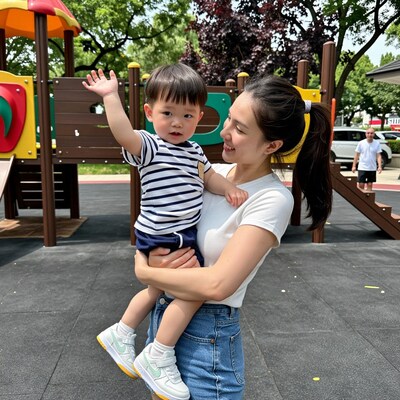 Asian mother holding toddler boy at playground