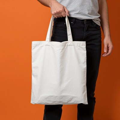 Man holding white tote bag